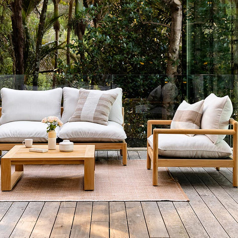 A stylish outdoor setting featuring Baya outdoor cushions and rug in a warm cumin brown