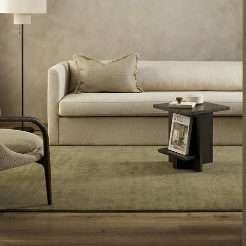 A stylish, muted green wool rug in a contemporary living room