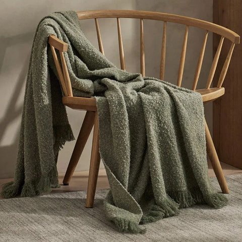A green boucle throw draped over a chair
