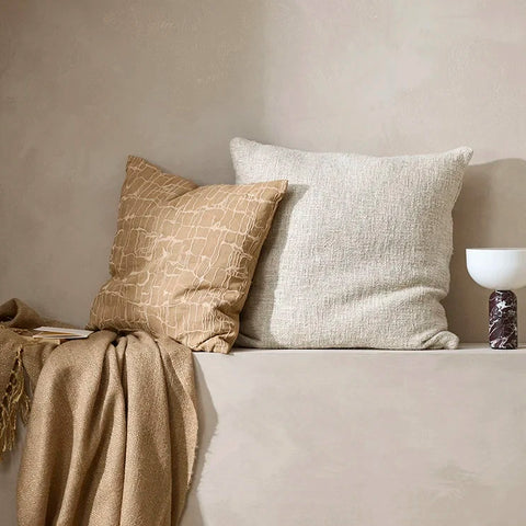 Brown and cream-toned home decor collection including cushions and throw blanket