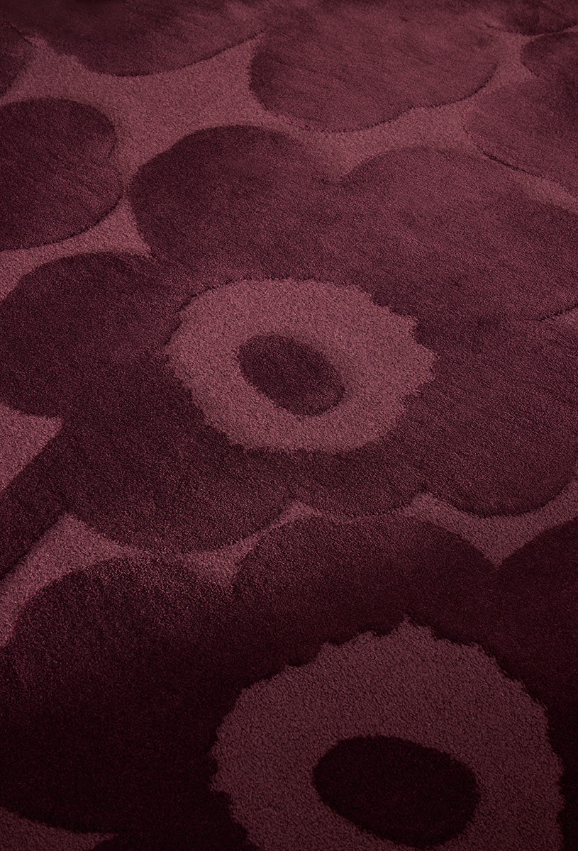 Close up of the Marimekko Unikko floral patterned rug with deep burgundy flowers at varying pile heights