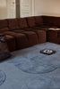 Marimekko Unikko floral patterned rug with mid blue flowers in a modern living room with brown couch