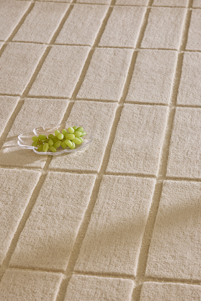 Close up of a Marimekko grid patterned rug in NZ wool and in a neutral creamy white
