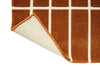 Corner close up of a Marimekko NZ wool grid patterned rug with corener folded up to show the backing