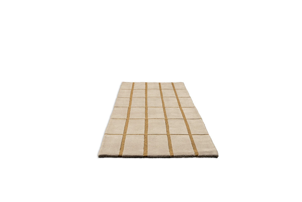 Perspective view of a Marimekko NZ wool beige runner rug with gold grid pattern 