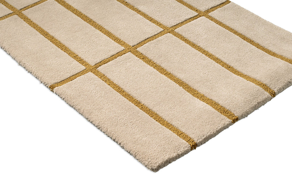 Corner view of a Marimekko NZ wool beige runner rug with gold grid pattern 
