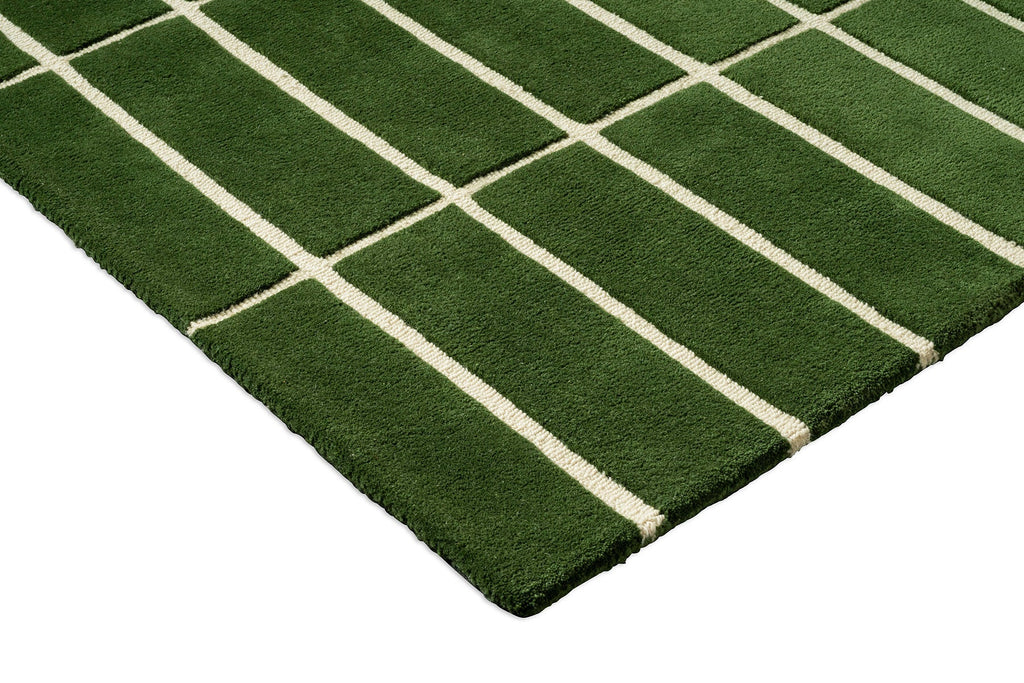 Close up corner view of a green geometric Marimekko NZ wool rug 
