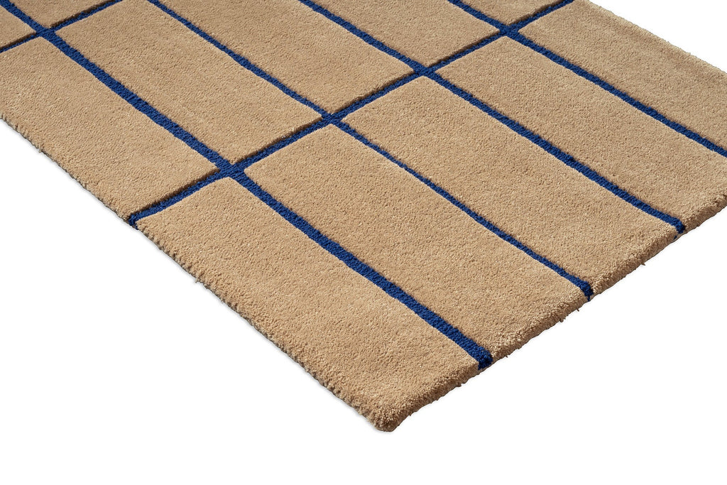 Close up of a Marimekko NZ wool runner rug with blue grid pattern on a beige  background