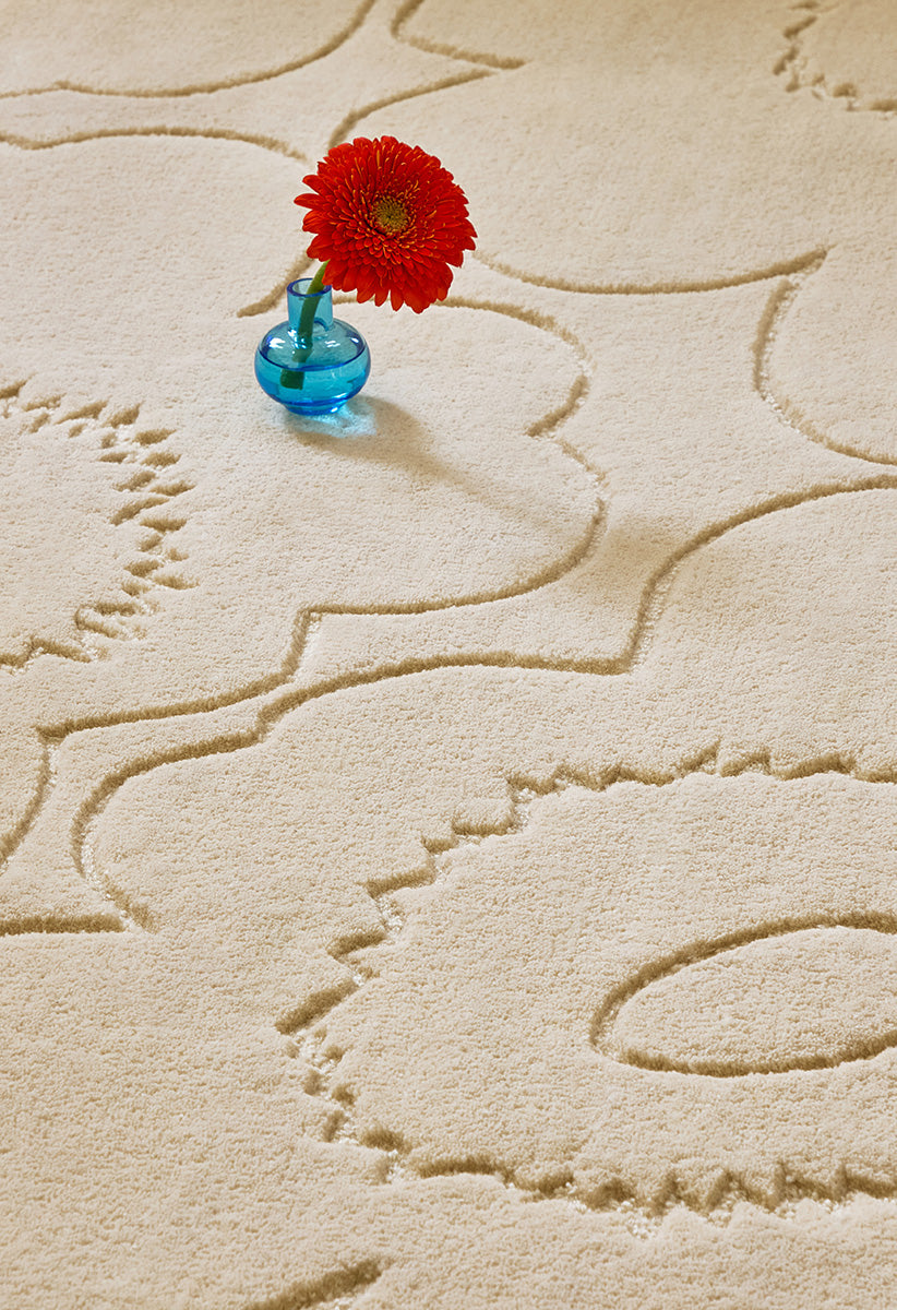 Close up o f a Marimekko runner rug in a creamy white with a subtle graphic cut into it