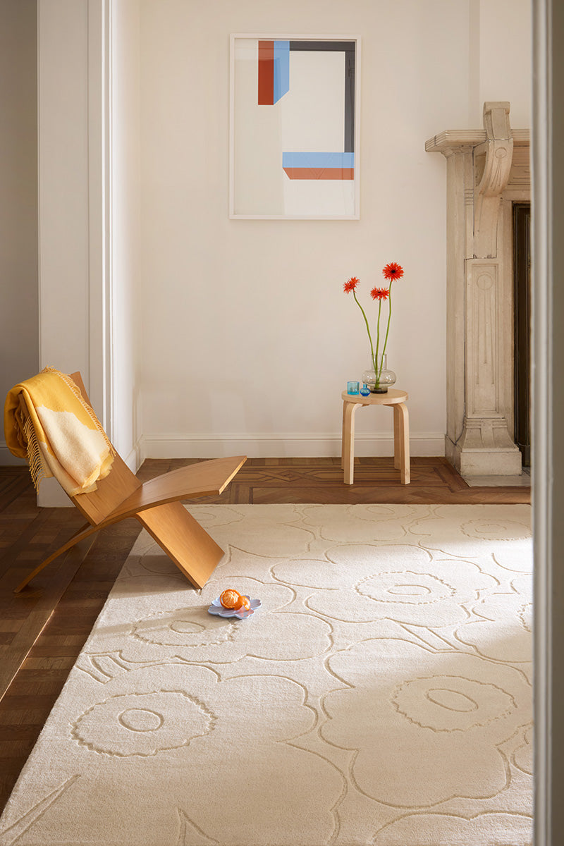 Modern interior with a gold chair, abstract art, and a creamy white Marimekko NZ wool rug 
