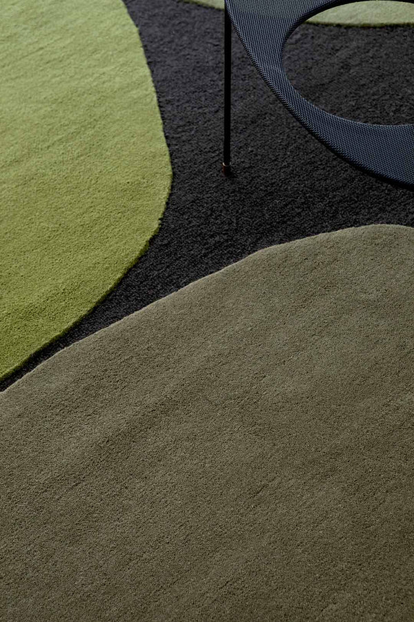 A close up of the green patterned shapes within the Plateau Moss wool floor rug by Brink & Campman