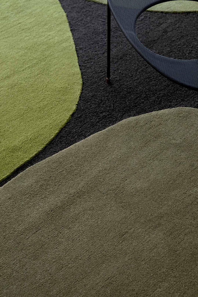 A close up of the green patterned shapes within the Plateau Moss wool floor rug by Brink & Campman