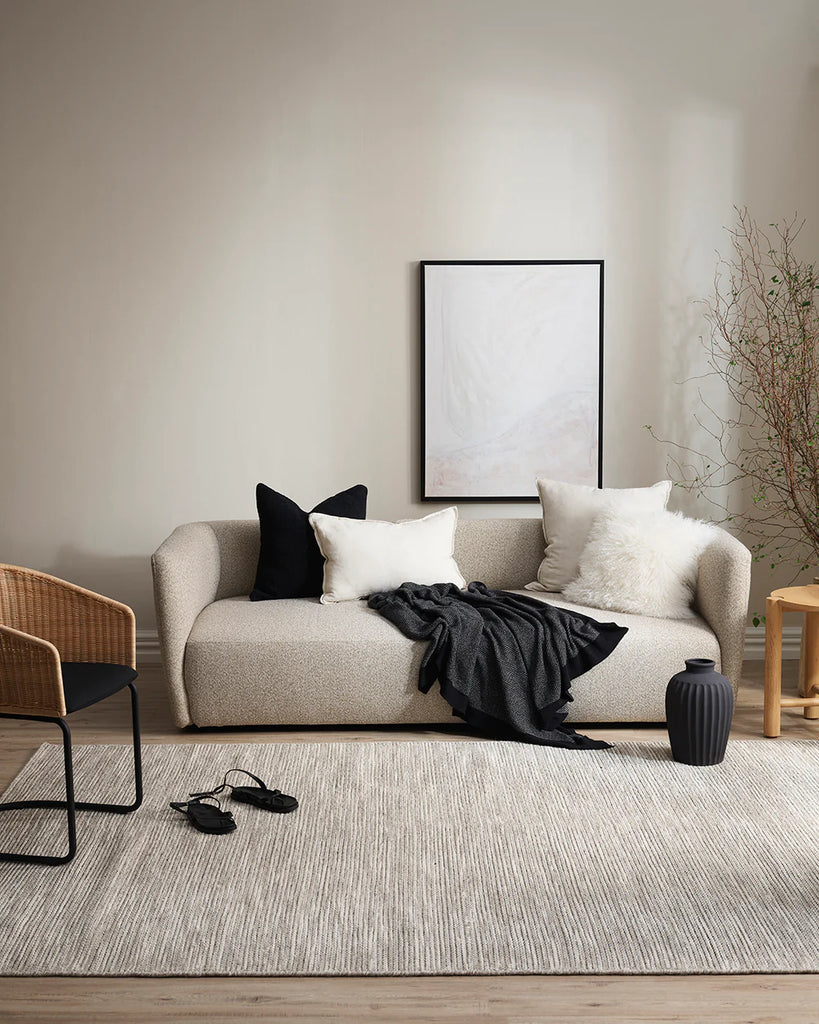 A contemporary living room featuring black and white home decor including the Baya cyprian cushions