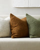 Three natural toned Baya cyprian cushions on a boucle couch