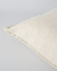 Corner detail showing flange of a cream linen cushion by Baya, the Cassia colour 'Almond'