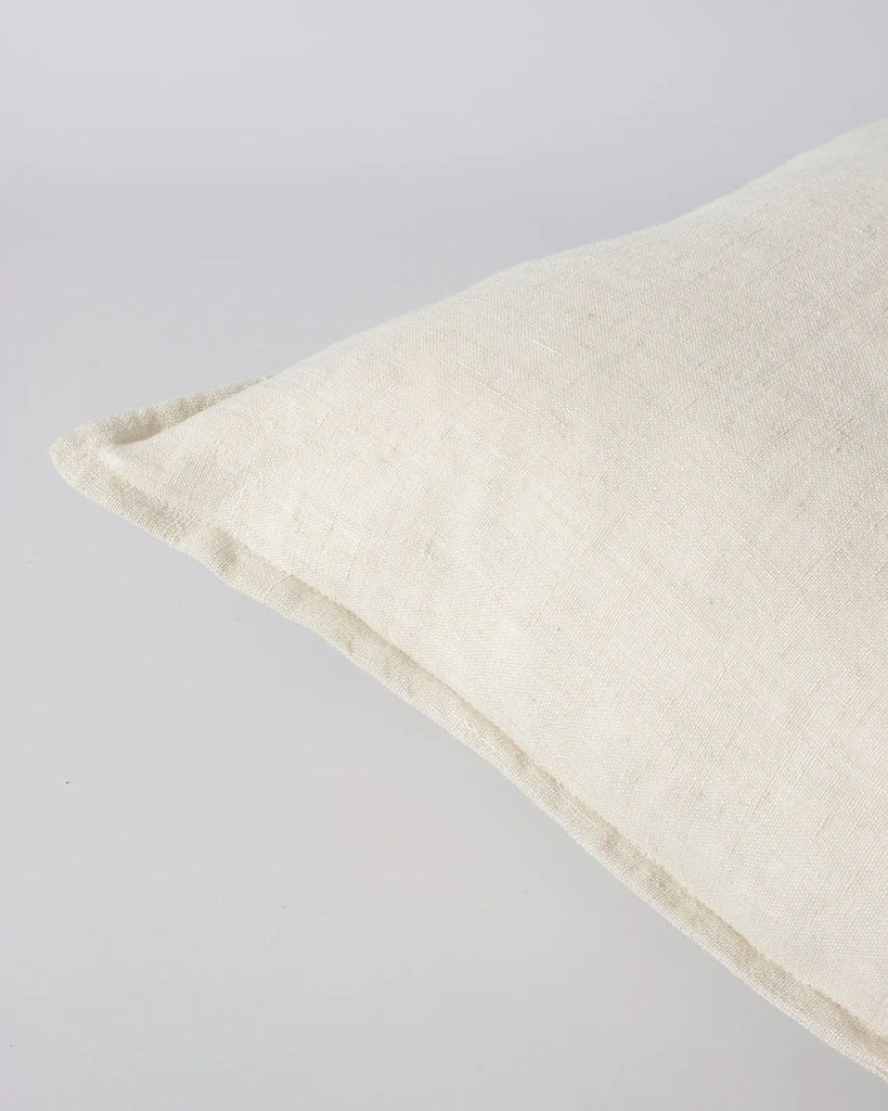 Corner detail showing flange of a cream linen cushion by Baya, the Cassia colour 'Almond'