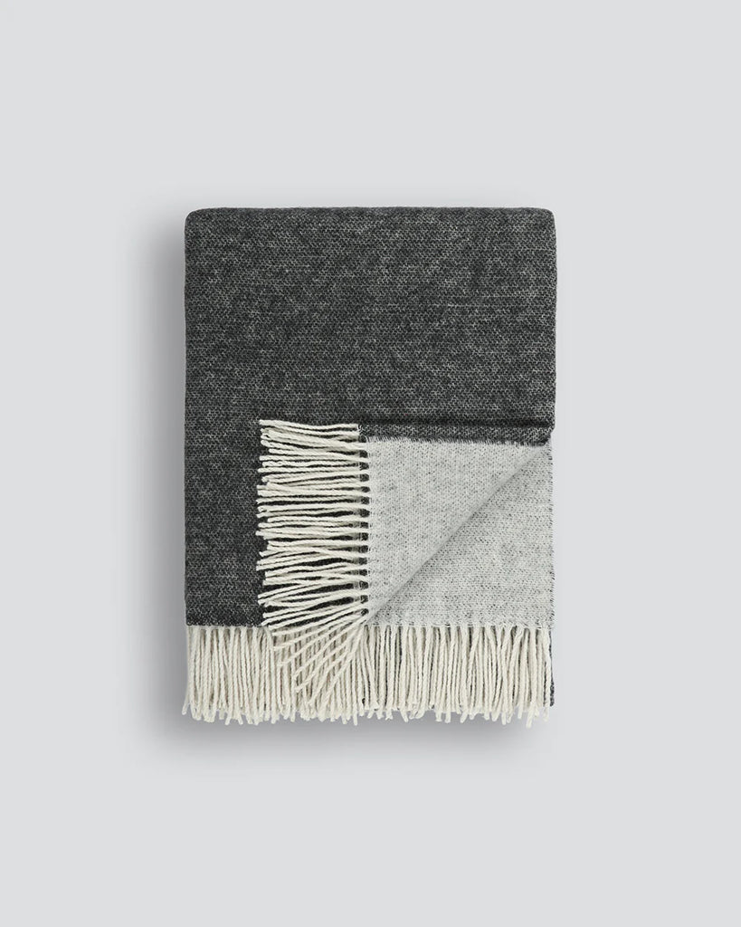 Two-toned charcoal and grey merino throw blanket folded to reveal both sides