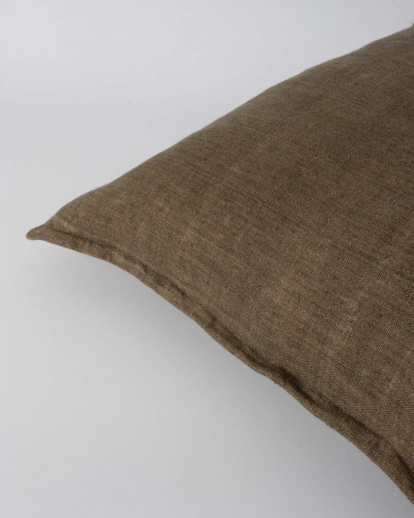 Corner of the Baya linen cushion in brown coloour 'Clove' showing the flange edge detail