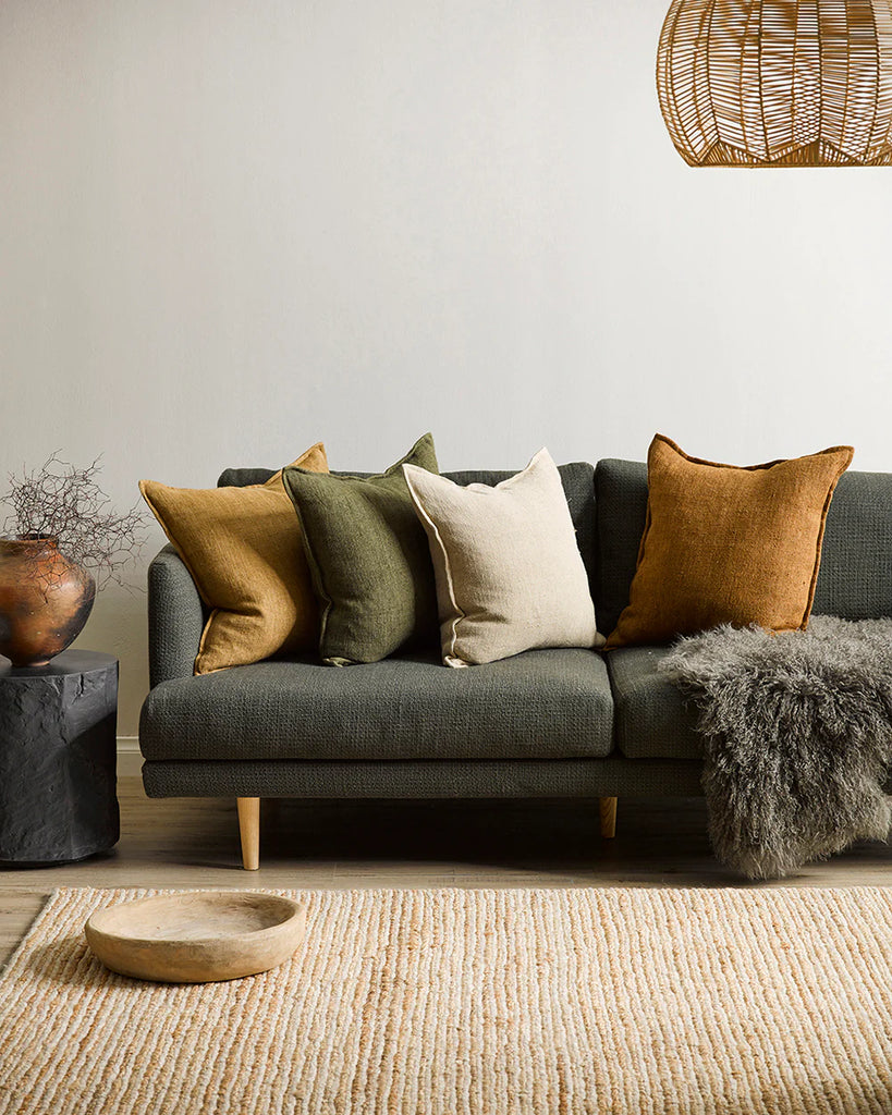 A modern living room featuring earthy tones and four Baya flaxmill linen cushions