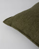 Close up of the Baya Flaxmill linen cushion with a flange edge, in colour moss green