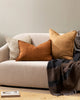 Baya linen cushions on a modern couch, featuring the square cushion Cassia in cumin brown