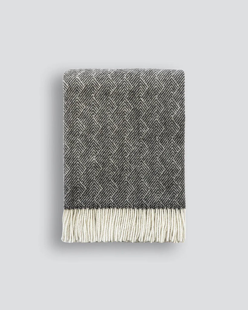 Baya Lana wool throw, featuring a feathery design and tassle fringe edge, in a soft black