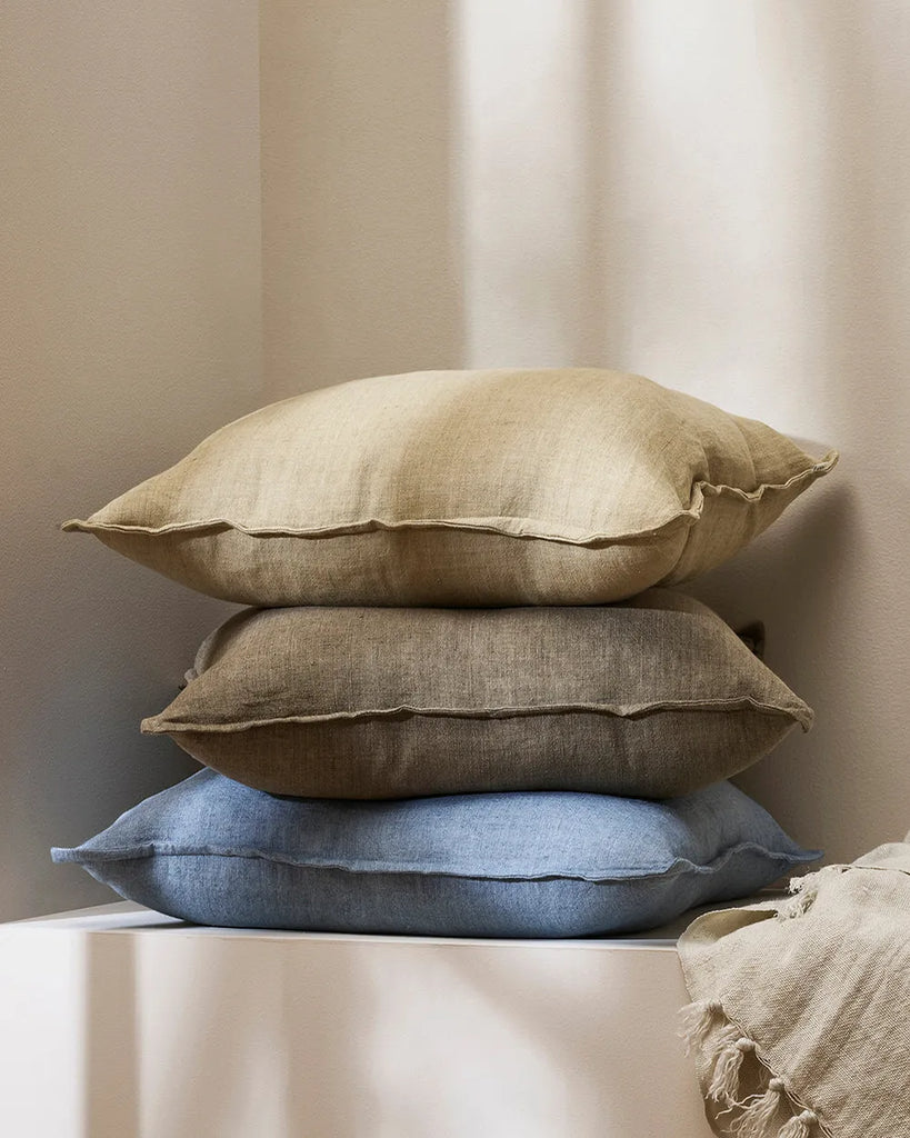 Close up of a stack of stylish Baya linen cushions in three contemporary colourways