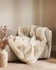 Soft, 'Pele' faux fur throw blanket, shown draped over a couch in a modern living room