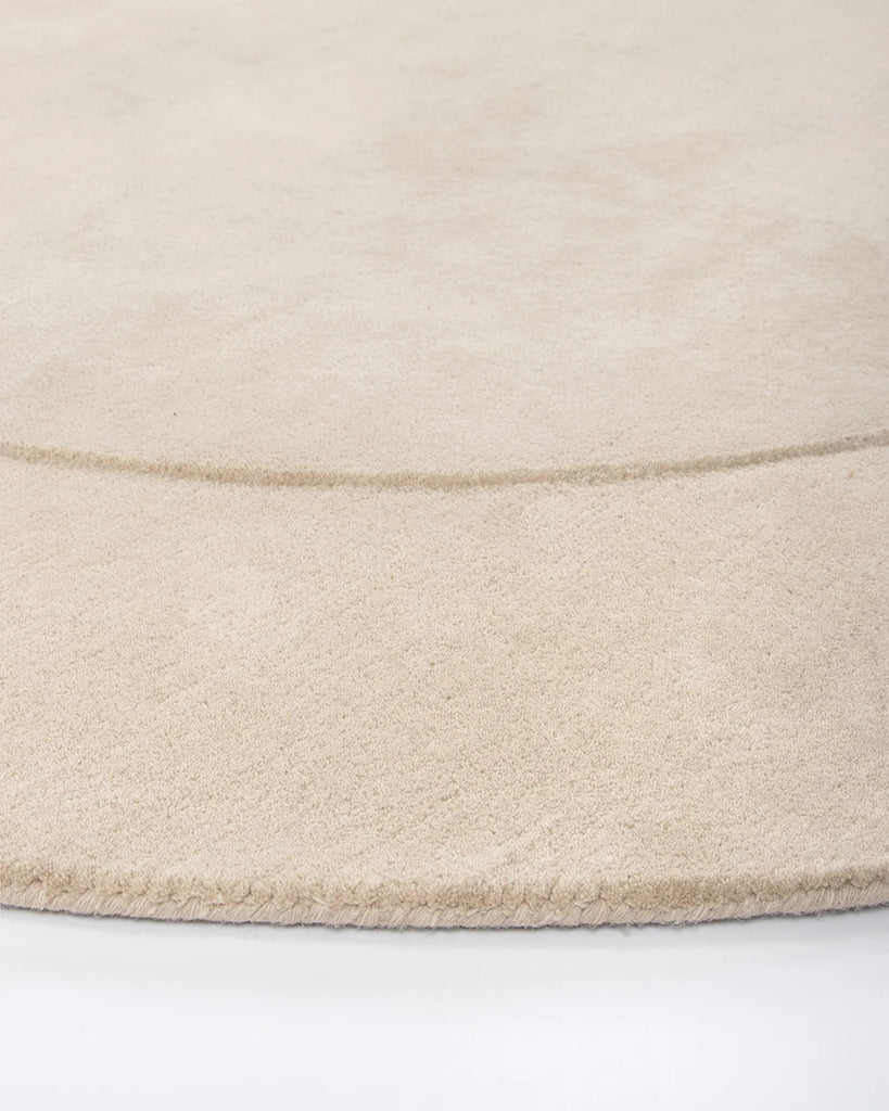 Edge detail of the Baya cream 'Form' curved floor rug