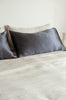 Silk pillowcase in colour slate grey, by Bianca Lorenne, shown styled on a bed
