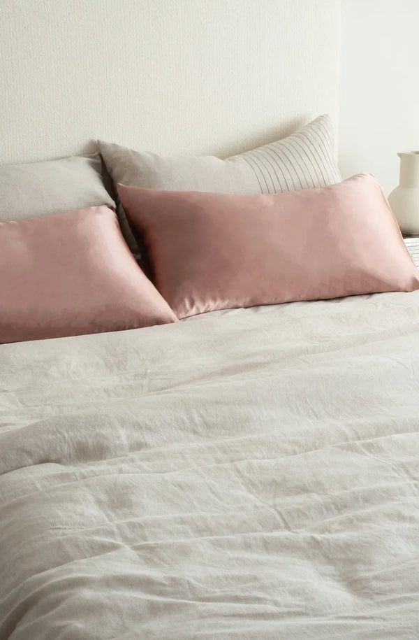 Elegant silk pillowcase by Bianca Lorenne, seen on a made bed in a minimalist bedroom