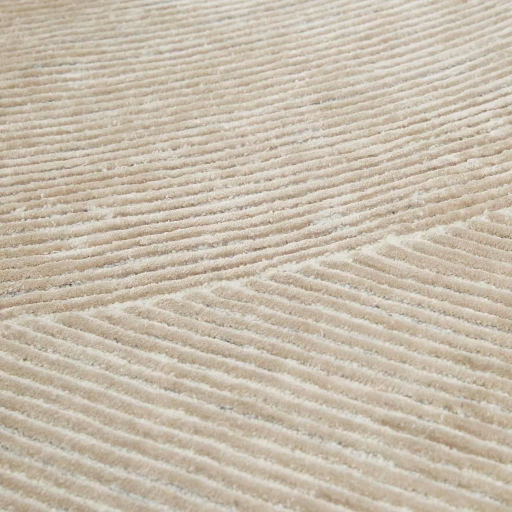 Close up of a cream, wool blend rug featuring a circle geometric design