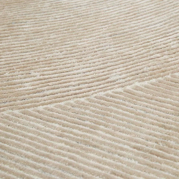 Close up of a cream, wool blend rug featuring a circle geometric design