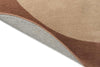 A warm brown and beige toned rug, with the corner flipped up to show the underside. 