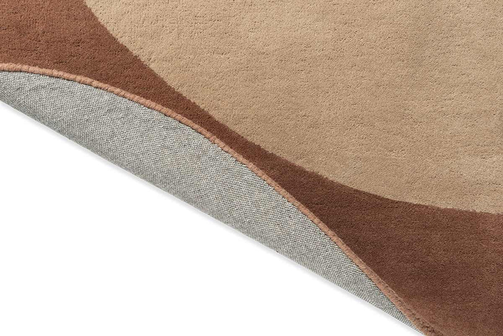 A warm brown and beige toned rug, with the corner flipped up to show the underside. 