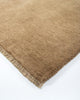 The Baya Sandringham light-mid brown 'Fenugreek' wool rug, seen close up at the corner highlighting the fringe detail