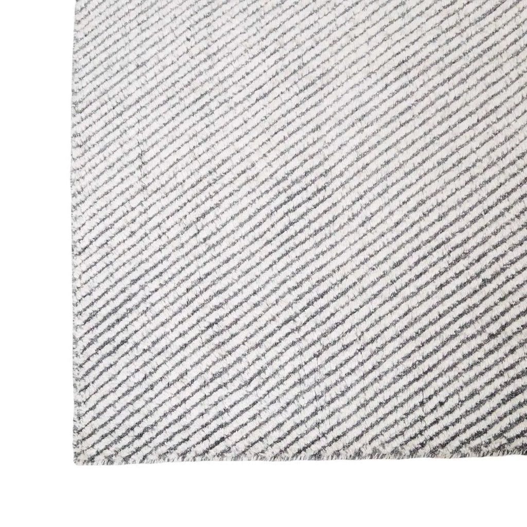 Close up of the corner of a charcoal and white patterned floor rug by Globe West and Soren Liv NZ