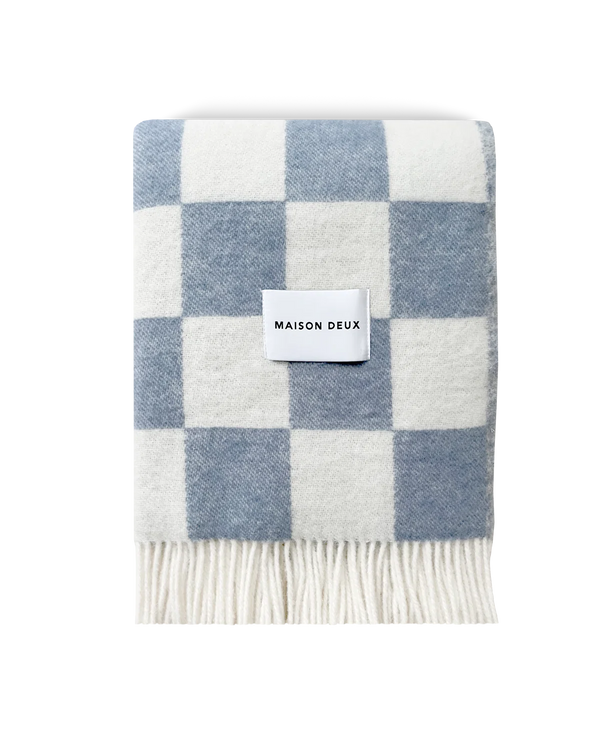 Maison Deux Checkerboard wool throw in Denim White, folded with the Maison Deux label visible.