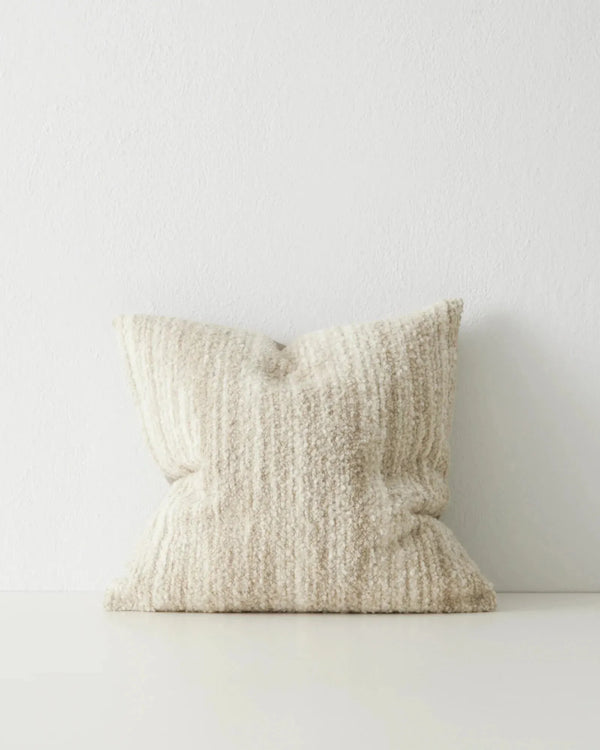 A natural, creamy beige coloured woven cushion with textural finish