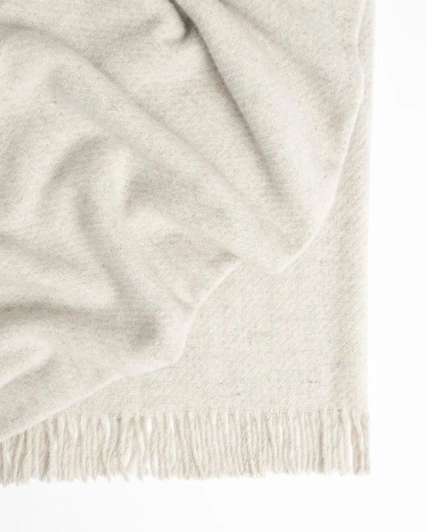 A soft creamy white recycled wool throw blanket with fringe, by Weave Home nz