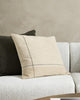 A couch styled with cushions in beige, taupe, cream and camel tones, with highlights of forest green by Baya.