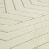 Close up of a cream/ivory wool floor rug featuring a striking geometric design