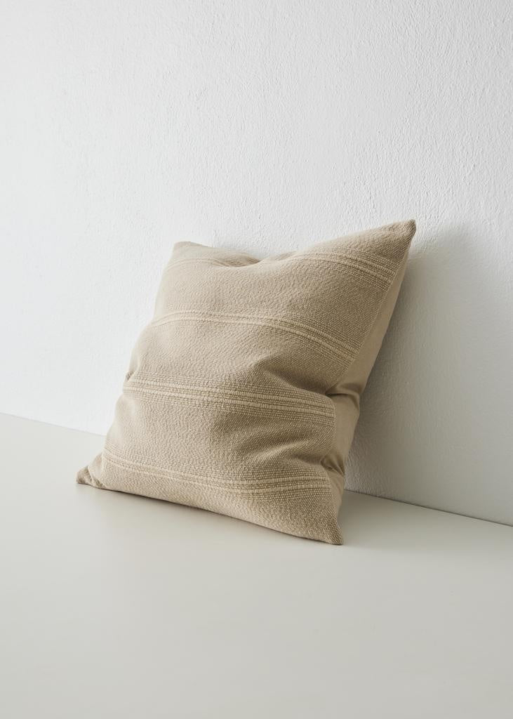 The 'Palma' cushion in colour 'Shell', a warm neutral - by Weave Home nz, seen in perspective, highlighting the subtle rib woven texture
