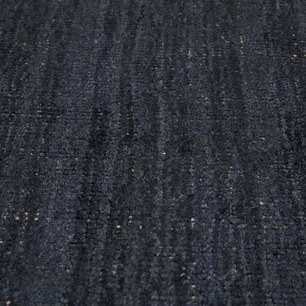 Close up of the weave of a dark blue wool blend floor rug