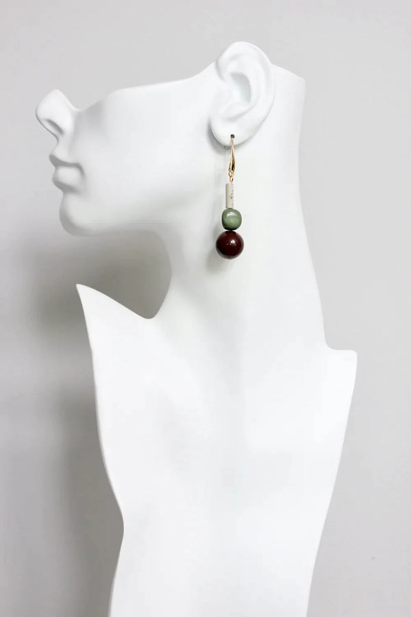 Designer earrings by David Aubrey featuring jasper and serpentine with a vintage bauble, shown hanging on a model for size reference