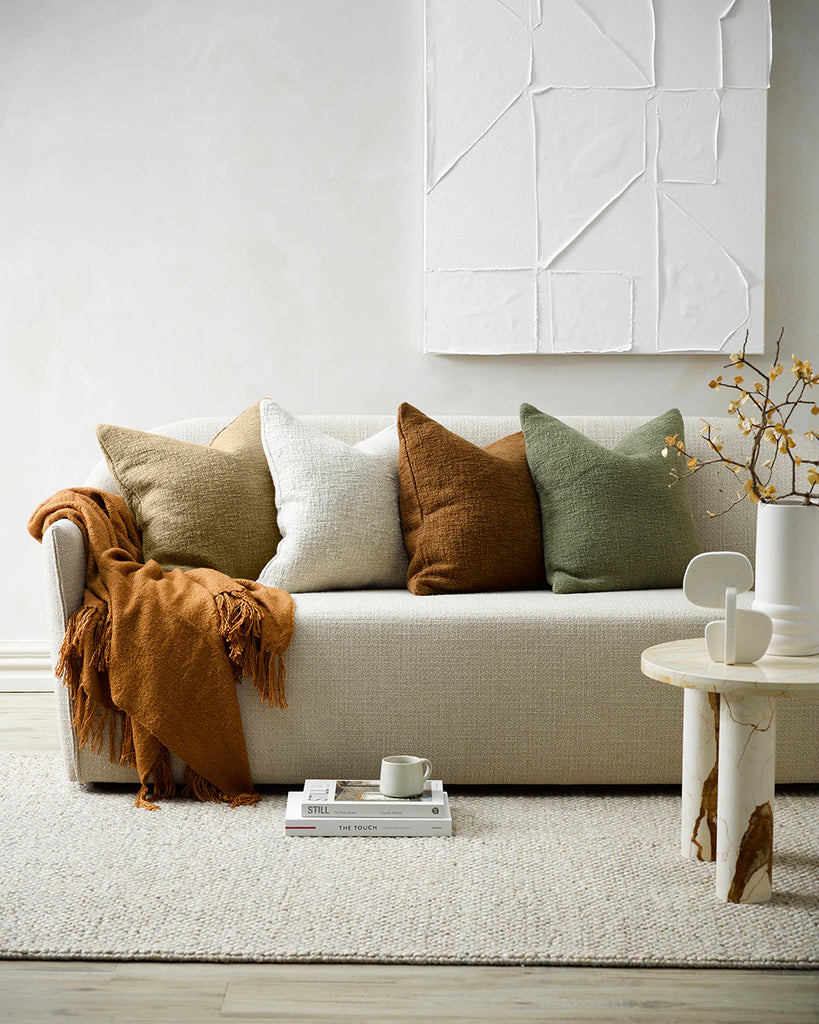 A light room with neutral decor, featuring earthy toned Baya cyprian cushions