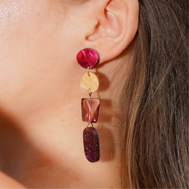 Close up of burgundy and orange dangle earrings by NZ designer Hagen + Co