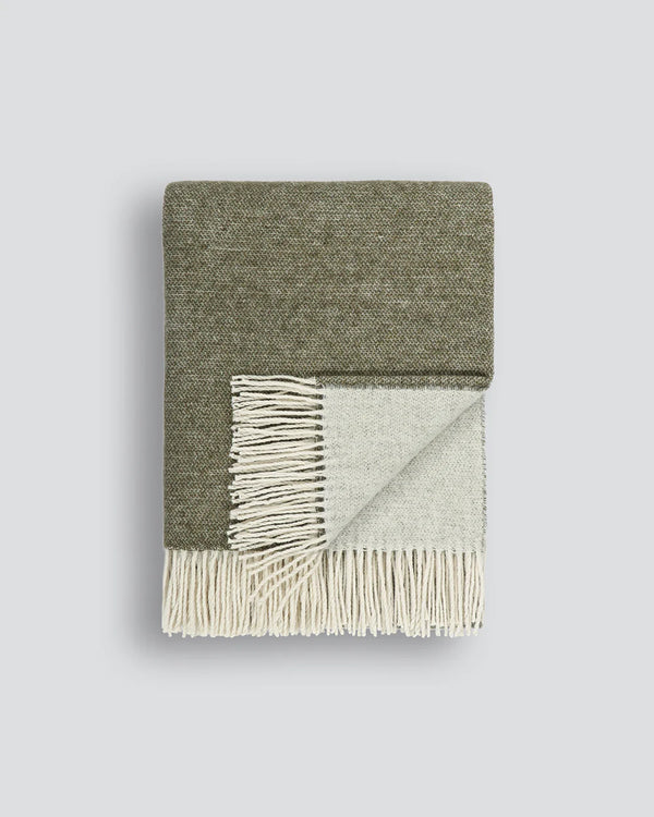 Folded merino throw blanket by Baya showing two tones of khaki green and cream