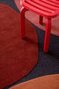 A close up of the red tones wihtin the Plateau Terra wool floor rug by Brink and Campman