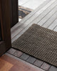 A doorway with a dark natural toned jute doormat. By Baya 